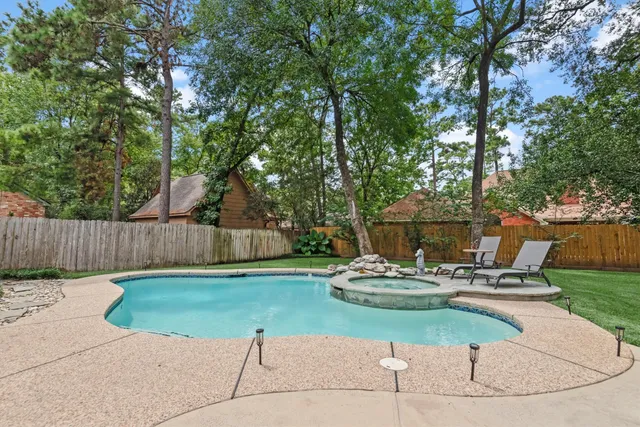 a view of a backyard with table and chairs potted plants and wooden fence