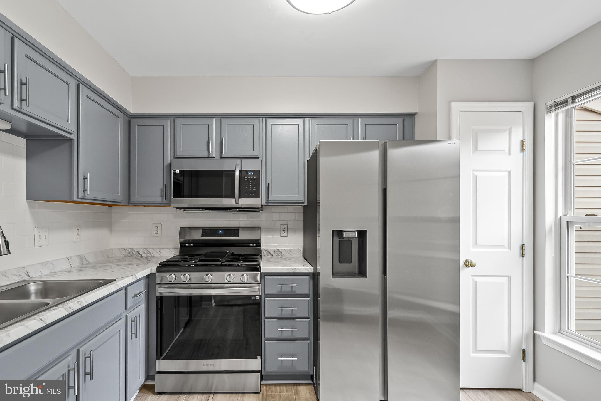 10305 Butternut Circle Manassas, VA 20110 - Photo 17 of 29 a kitchen with stainless steel appliances granite countertop a refrigerator stove and sink