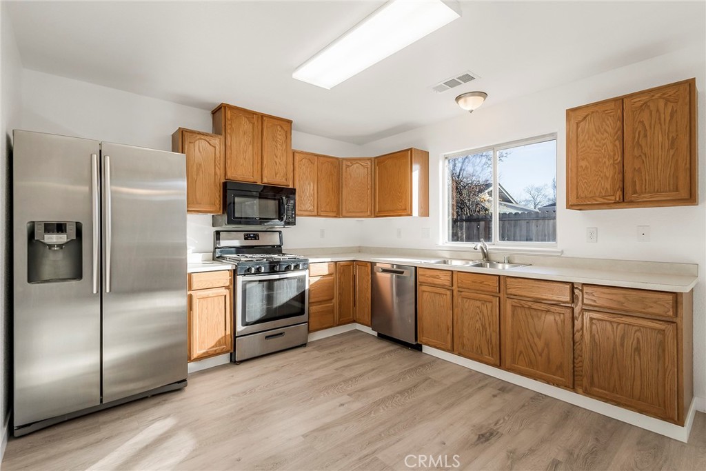 4 Cloud Court Chico, CA 95928 - Photo 16 of 46 a kitchen with granite countertop a refrigerator stove and microwave