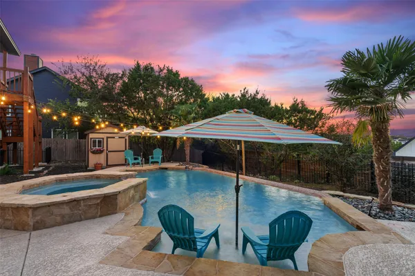 a view of backyard with swimming pool and fire pit