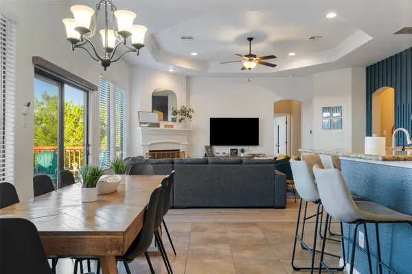 a view of a dining room with furniture a chandelier and a flat screen tv