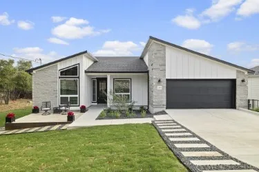 a front view of a house with a garden and patio