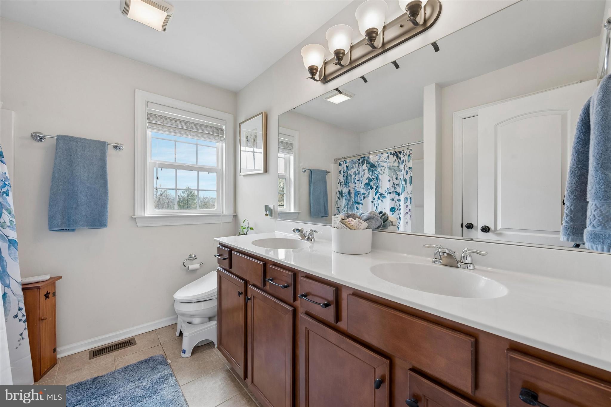 301 Jennifer Lane Exton, PA 19341 - Photo 26 of 41 a bathroom with a granite countertop sink a toilet a mirror and window