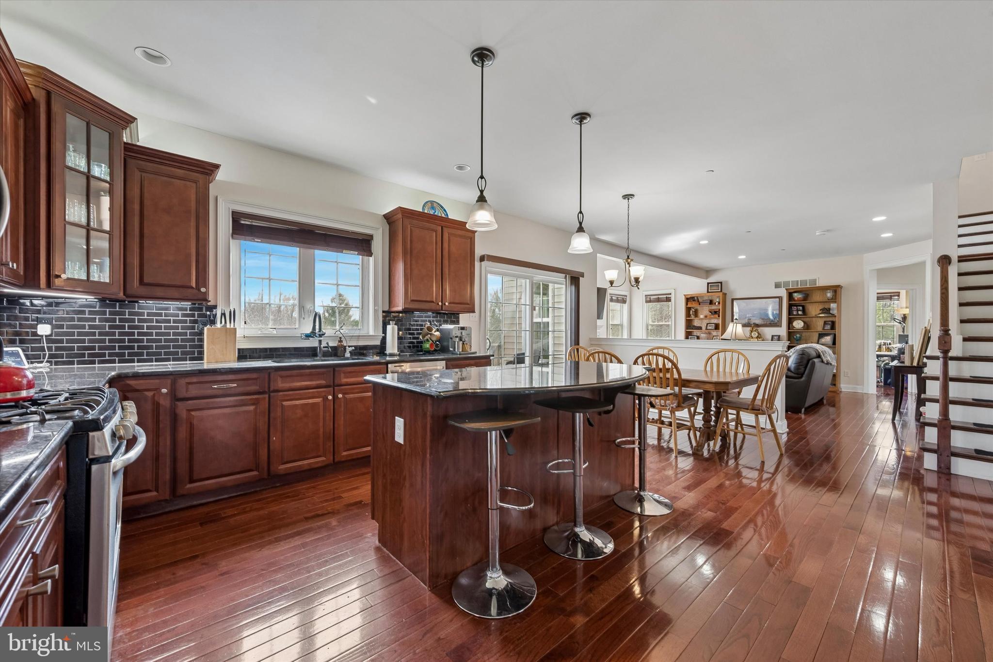 301 Jennifer Lane Exton, PA 19341 - Photo 7 of 41 a kitchen with stainless steel appliances granite countertop a stove a refrigerator a kitchen island a dining table and chairs with wooden floor