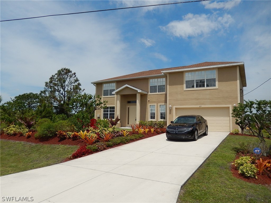 425 Jourferie Road Lehigh Acres, FL 33974 - Photo 1 of 25 a house view with a garden space
