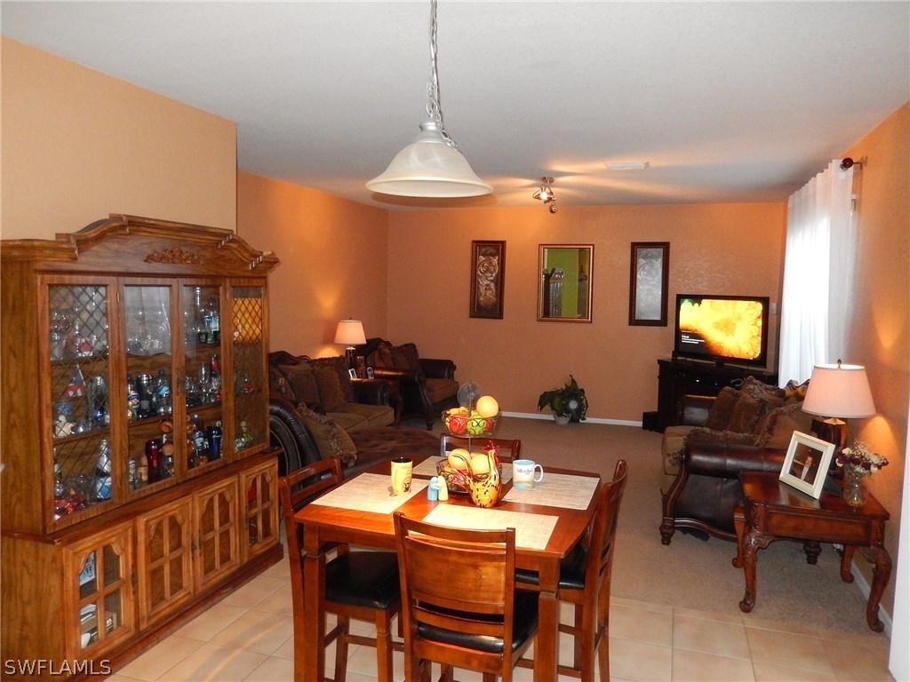 425 Jourferie Road Lehigh Acres, FL 33974 - Photo 11 of 25 a view of a dining room with furniture and chandelier