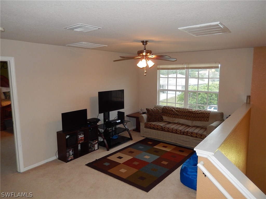 425 Jourferie Road Lehigh Acres, FL 33974 - Photo 14 of 25 a living room with furniture and a flat screen tv