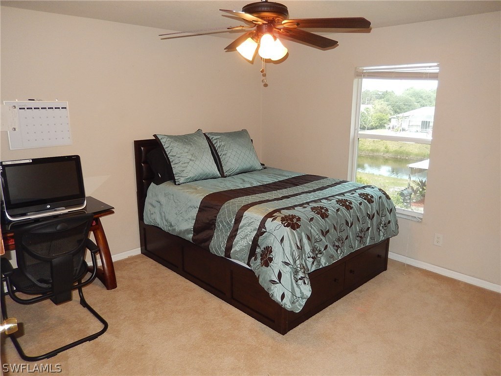 425 Jourferie Road Lehigh Acres, FL 33974 - Photo 20 of 25 a bedroom with a bed gym equipment and a window
