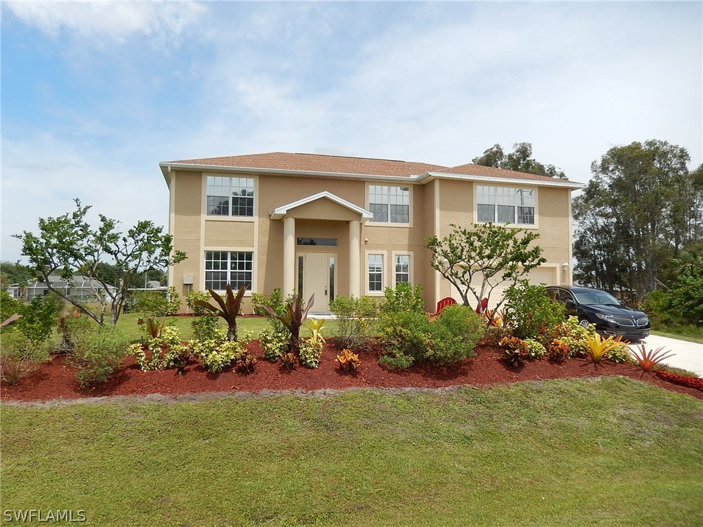425 Jourferie Road Lehigh Acres, FL 33974 - Photo 2 of 25 a front view of a house with a yard