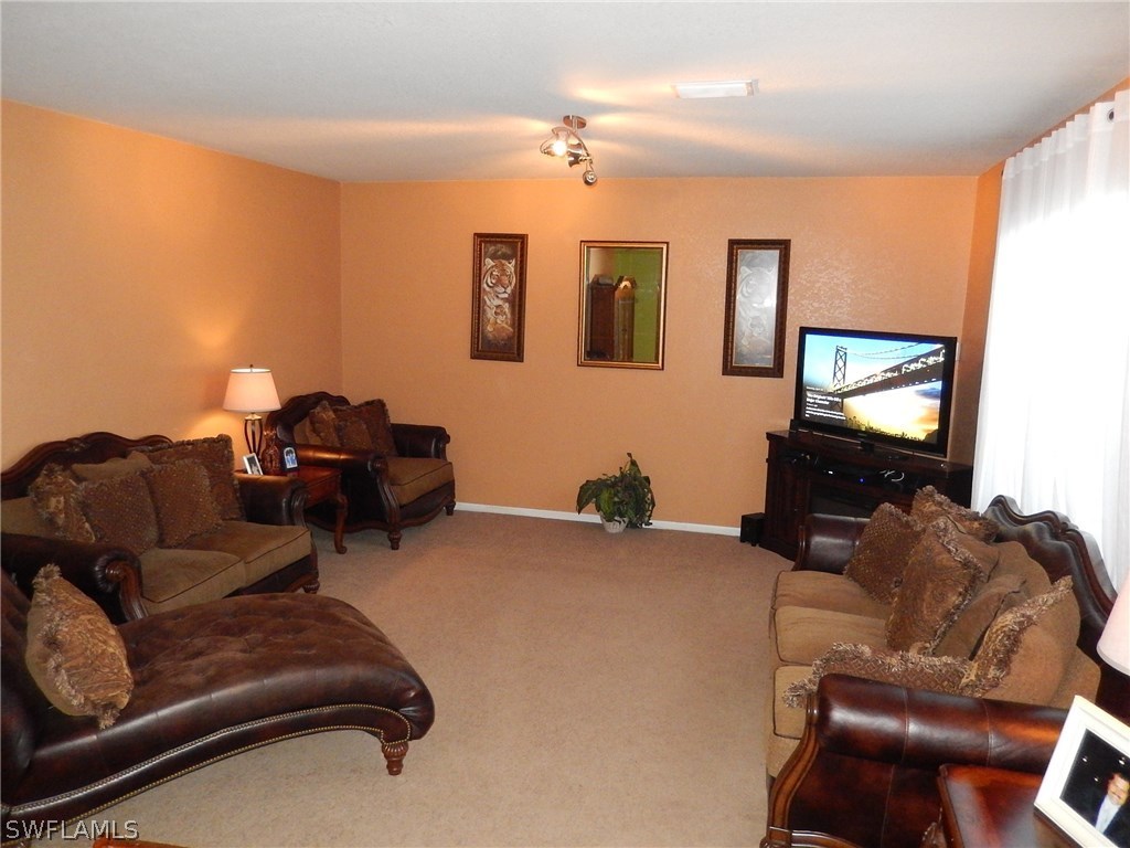 425 Jourferie Road Lehigh Acres, FL 33974 - Photo 5 of 25 a living room with furniture and a flat screen tv