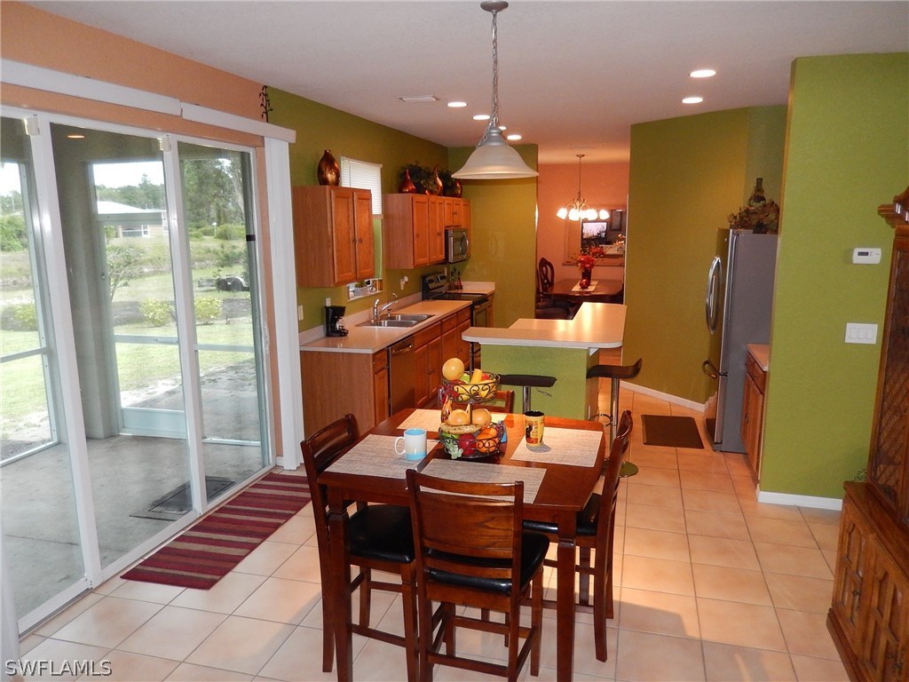 425 Jourferie Road Lehigh Acres, FL 33974 - Photo 6 of 25 a dining room with furniture and a floor to ceiling window