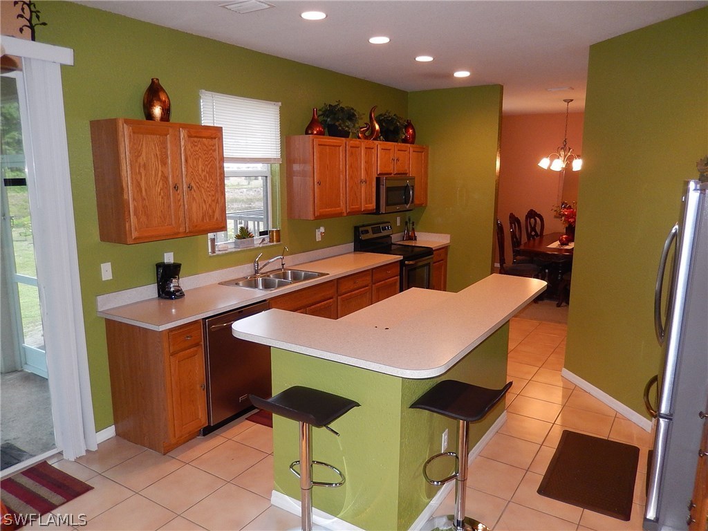 425 Jourferie Road Lehigh Acres, FL 33974 - Photo 7 of 25 a kitchen that has a sink and a table in it