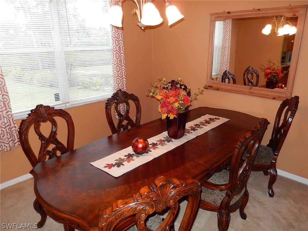 425 Jourferie Road Lehigh Acres, FL 33974 - Photo 9 of 25 a view of a dining room with furniture and chandelier