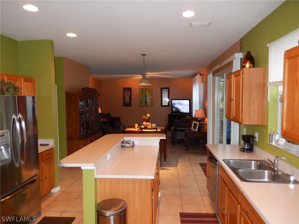 425 Jourferie Road Lehigh Acres, FL 33974 - Photo 10 of 25 a kitchen with stainless steel appliances a sink stove and refrigerator
