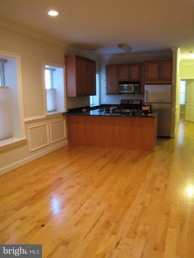 1740 18th Street Northwest, Unit 104 Washington, DC 20009 - Photo 3 of 13 a kitchen with stainless steel appliances granite countertop a stove a sink and a refrigerator