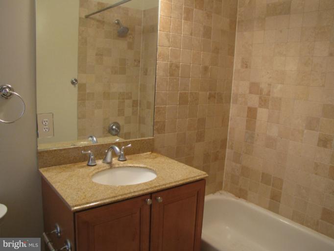 1740 18th Street Northwest, Unit 104 Washington, DC 20009 - Photo 7 of 13 a bathroom with a granite countertop sink shower and a mirror