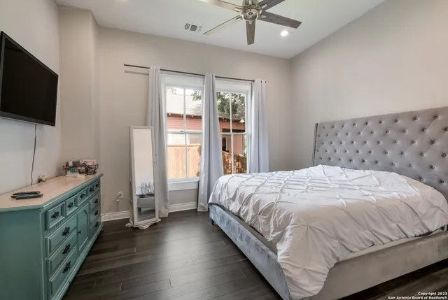 a bedroom with a large bed and a flat tv screen on dresser
