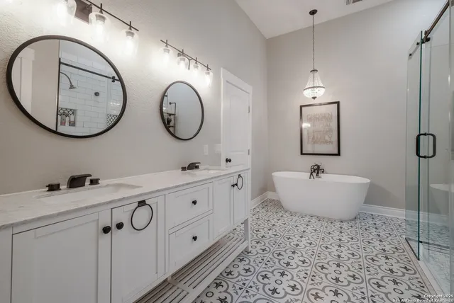 a bathroom with a double vanity sink mirror and bathtub