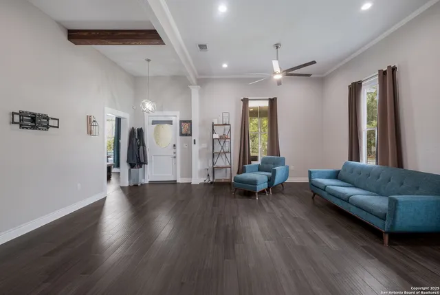 a living room with furniture and a wooden floor
