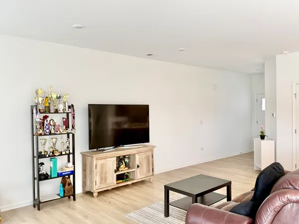 a living room with stainless steel appliances furniture a couch and a kitchen view