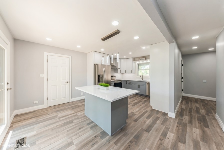 135 Timber Hill Road Buffalo Grove, IL 60089 - Photo 7 of 22 a view of kitchen island wooden floor center island and stainless steel appliances