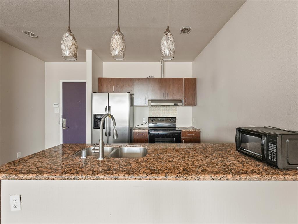 a kitchen with stainless steel appliances granite countertop a sink a stove and a microwave