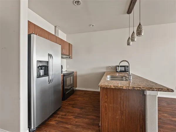 a kitchen with kitchen island a sink appliances and wooden floor