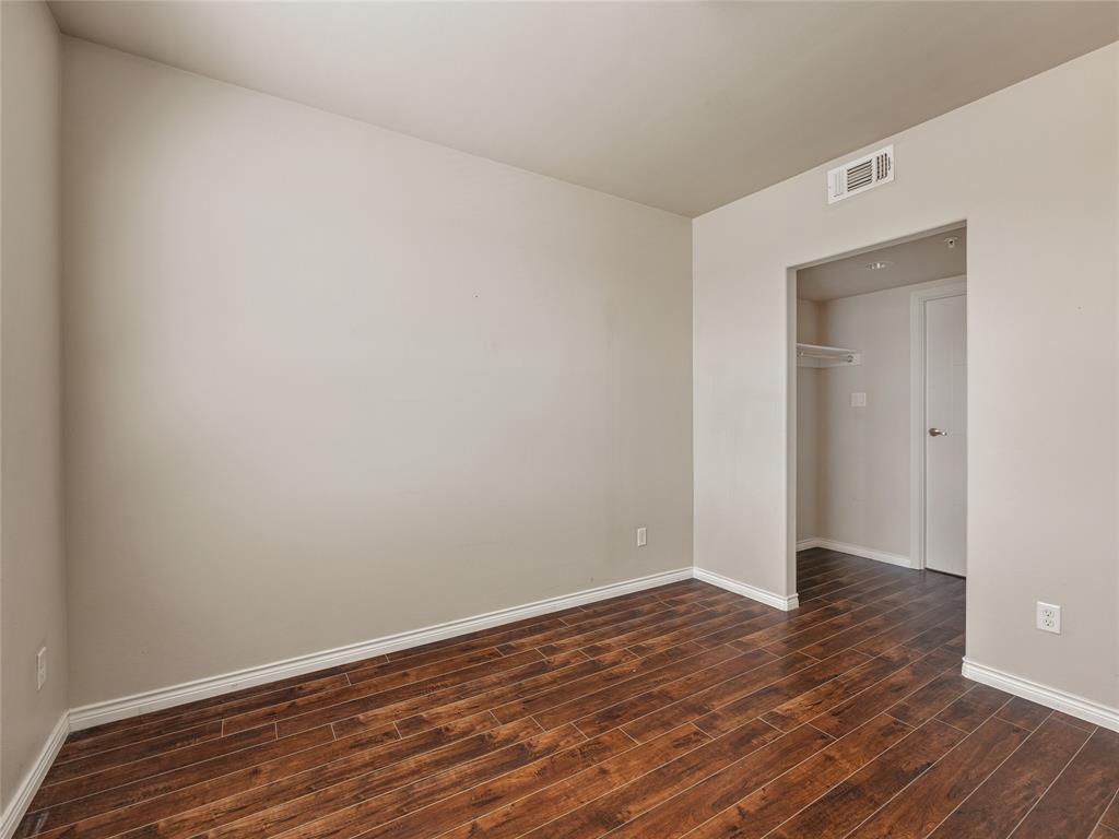 1100 West Trinity Mills Road, Unit 3032 Carrollton, TX 75006 - Photo 9 of 31 a view of an empty room with wooden floor