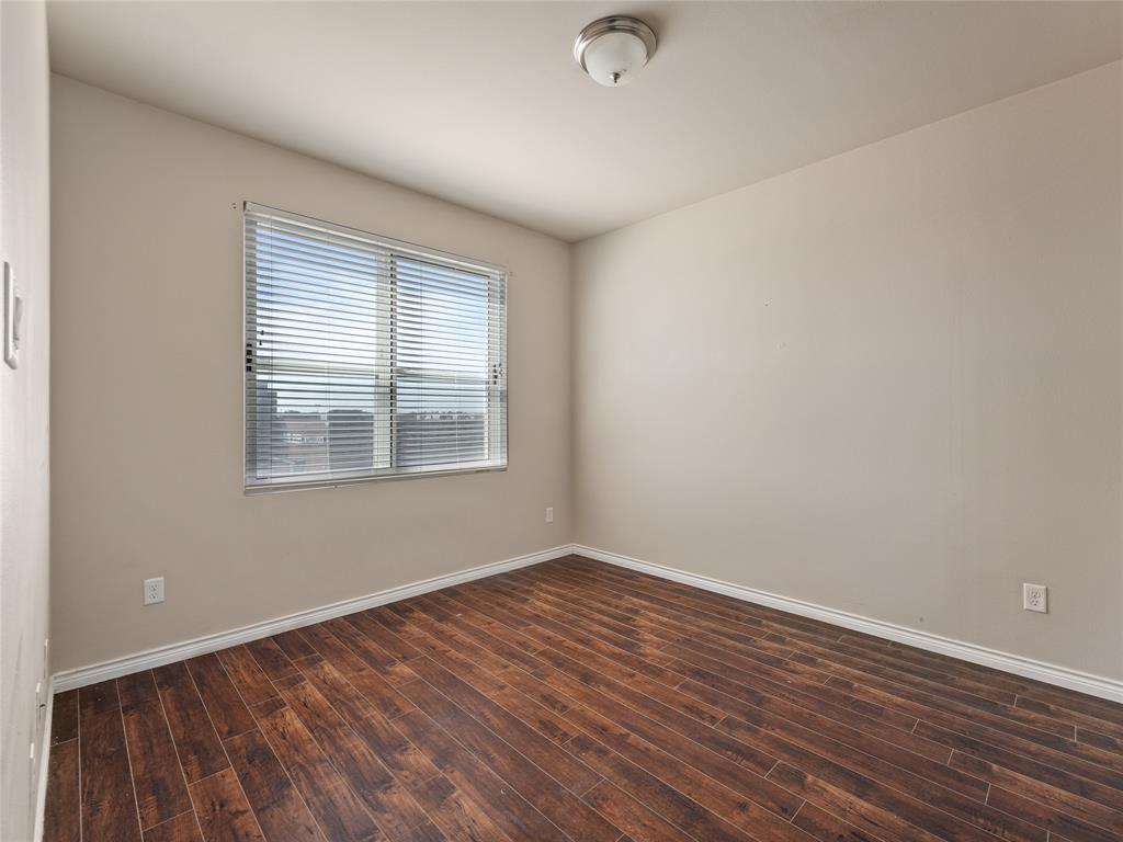 1100 West Trinity Mills Road, Unit 3032 Carrollton, TX 75006 - Photo 10 of 31 wooden floor in an empty room with a window
