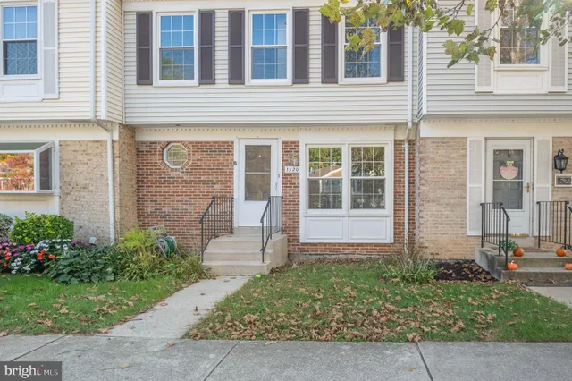 front view of a brick house with a yard