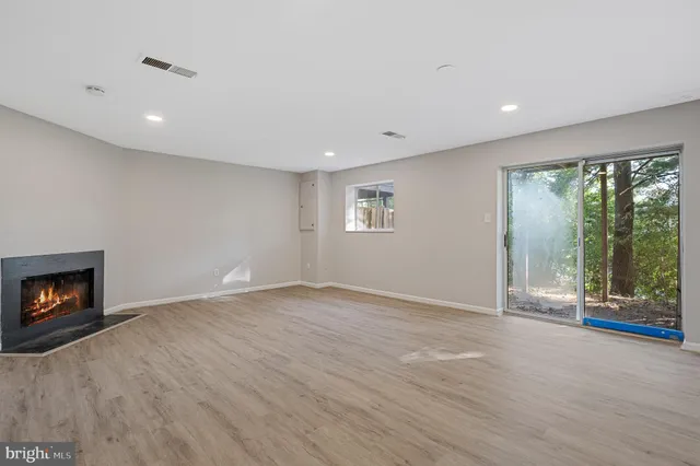 a view of an empty room with a fireplace and a window