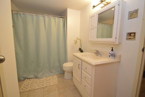 146 Marble Street, Unit 211 Stoneham, MA 02180 - Photo 18 of 20 a bathroom with a sink a toilet and shower