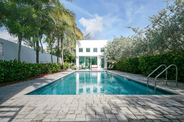a kitchen with stainless steel appliances kitchen island granite countertop a table chairs and a refrigerator
