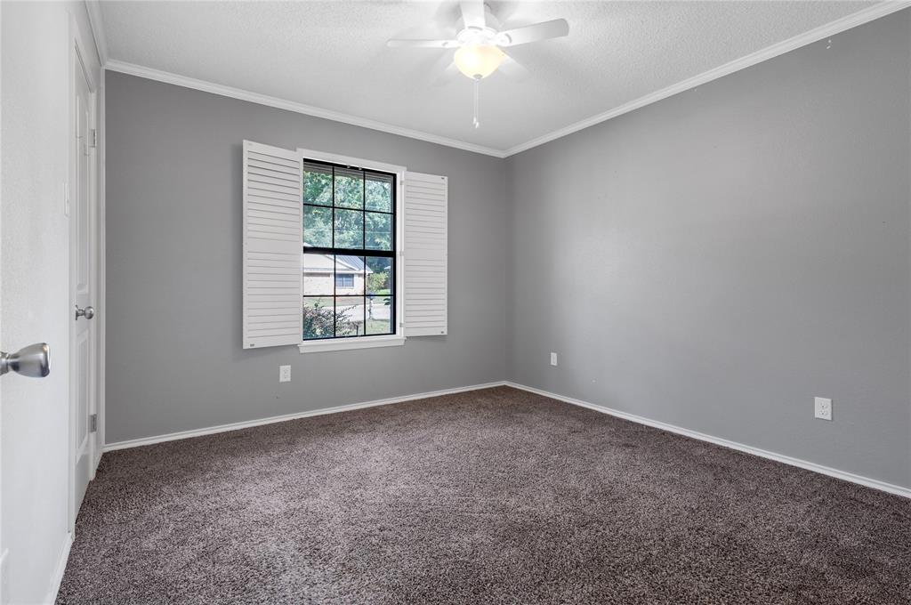 1609 Robin Street Mineola, TX 75773 - Photo 12 of 24 Window with white louvered shutters, complemented by a ceiling fan with integrated lighting