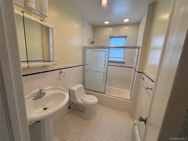a bathroom with a sink a toilet a mirror and shower