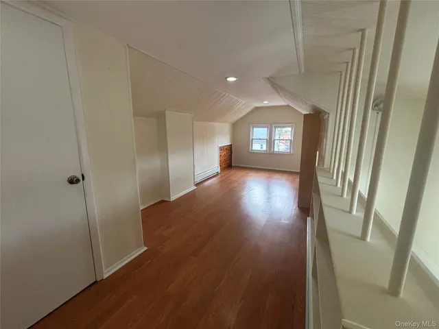 a view of a hallway with wooden floor and a living room