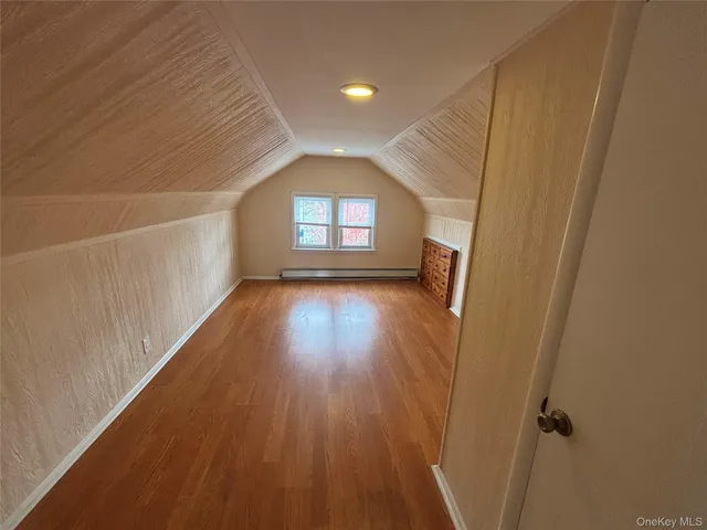 a view of a room with wooden floor and a window