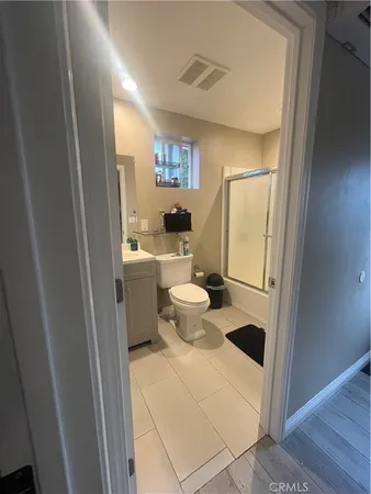 a bathroom with a sink a toilet and shower a window