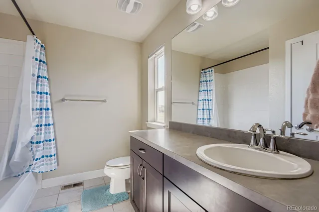 a bathroom with a granite countertop sink toilet a mirror and shower