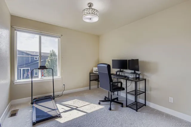 a view of a workspace with furniture and a window