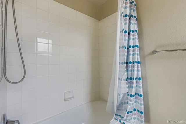 a bathroom with a shower curtain and a window