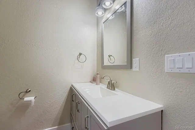 a bathroom with a sink vanity and a mirror