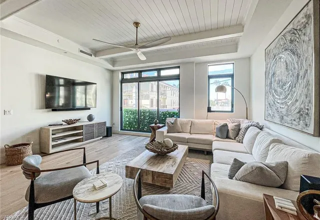 a living room with furniture flat screen tv and a large window