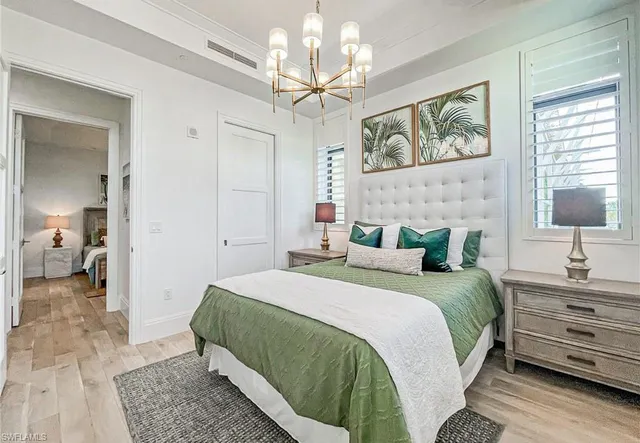 a bedroom with a bed and a chandelier