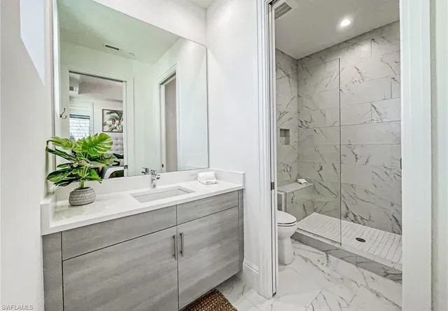 a bathroom with a shower sink and mirror