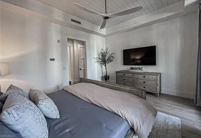 a bedroom with a bed and a flat tv screen on wall