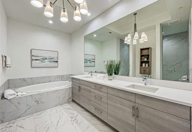 a bathroom with a double vanity sink a large mirror a bathtub and shower