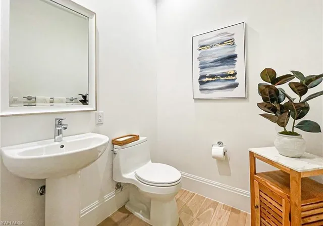 a bathroom with a sink mirror toilet and vanity