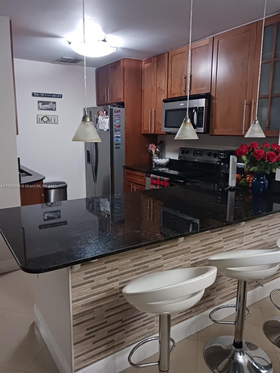 8340 Southwest 154th Avenue, Unit 63 Miami, FL 33193 - Photo 15 of 18 a kitchen with refrigerator and chairs