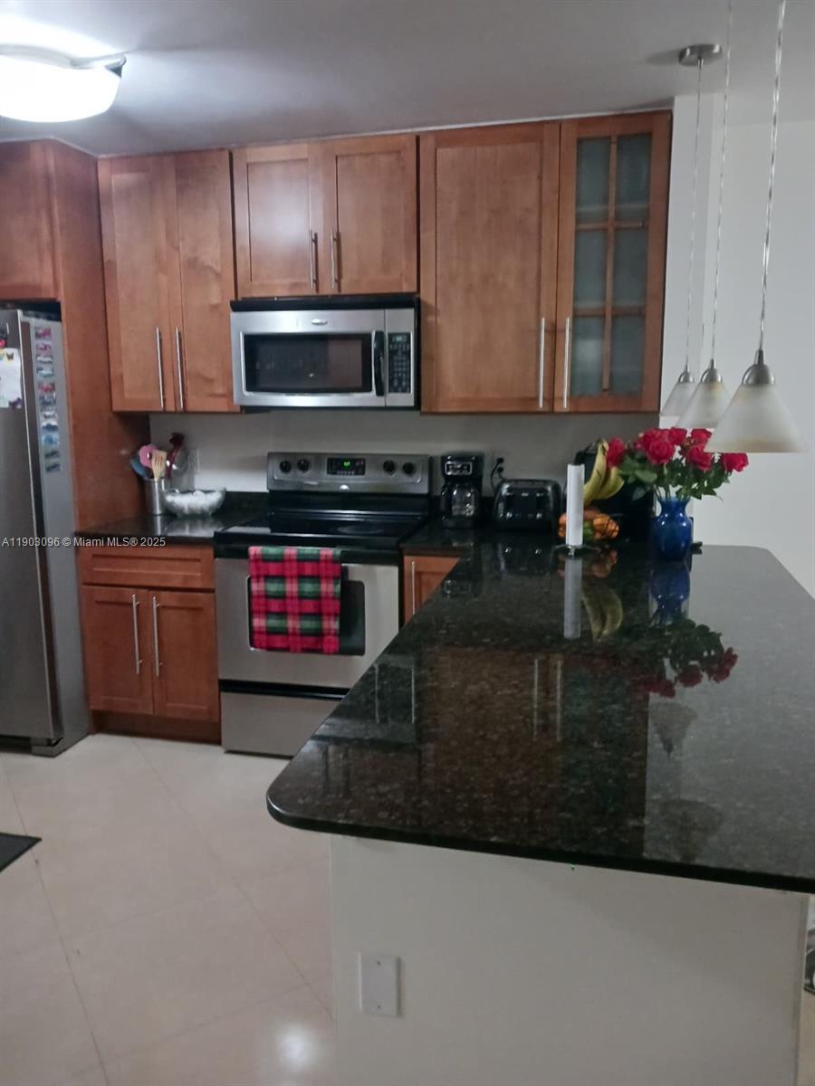 8340 Southwest 154th Avenue, Unit 63 Miami, FL 33193 - Photo 17 of 18 a kitchen with stainless steel appliances granite countertop a sink stove and cabinets